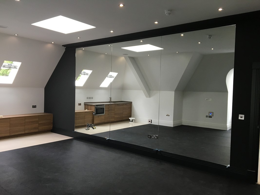 Frameless glass wall dividing loft conversion in Alexandra Palace